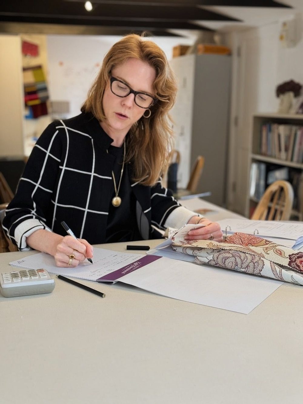 Working through fabric samples and drawings at a workroom table