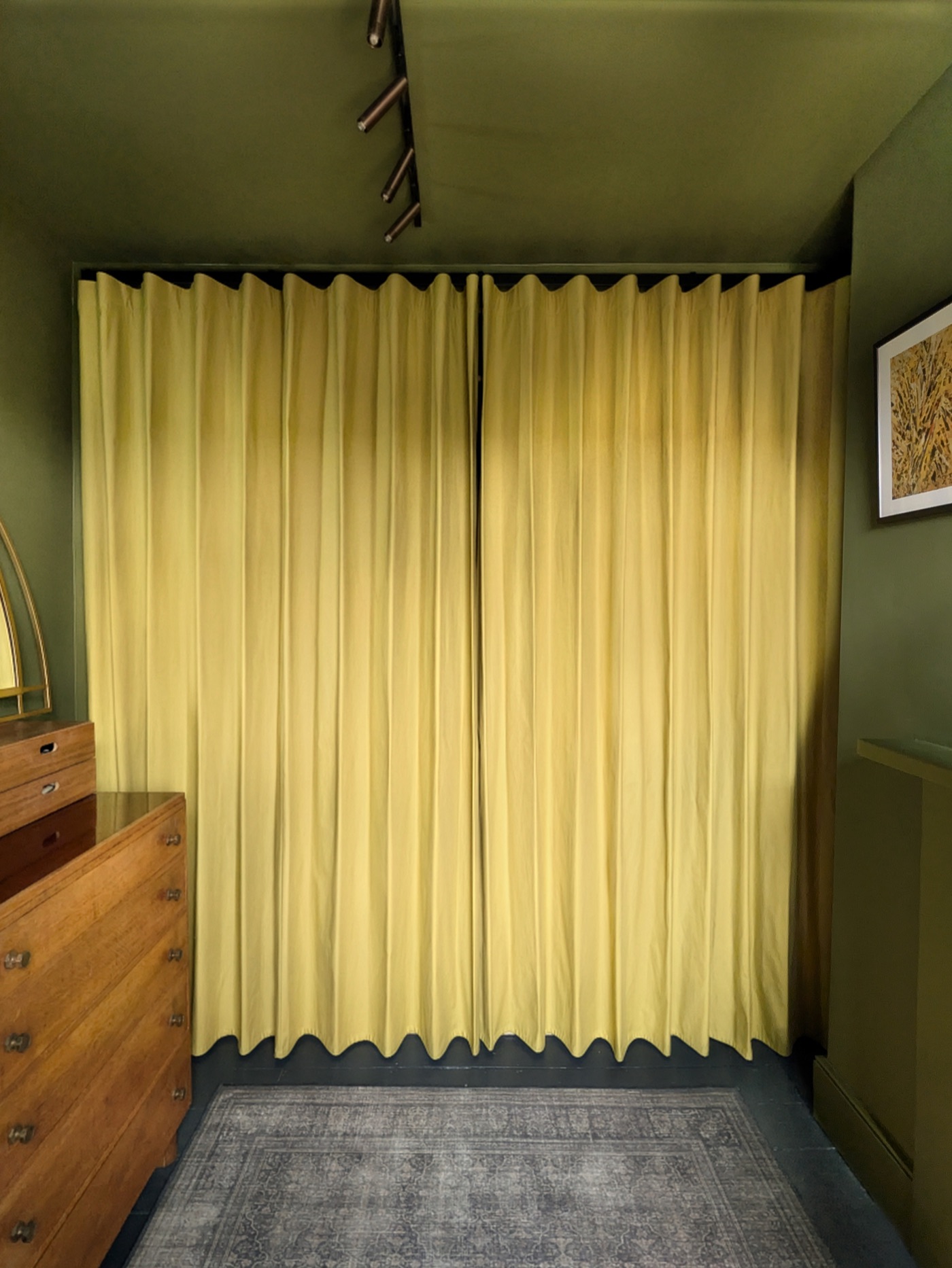 Soft yellow Cotton Wave curtains hung wall to wall, with the wave heading rippling along the track